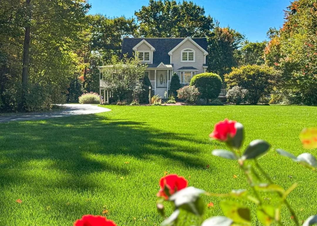 A classic New England colonial home with a green lawn